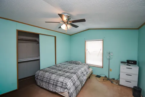 a bedroom with a bed and a ceiling fan