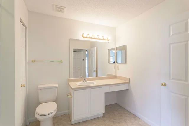 a bathroom with a toilet a sink and mirror