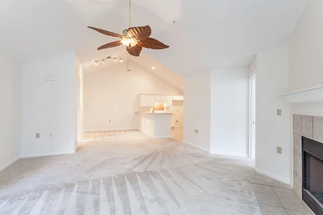 a view of a livingroom with a ceiling fan and kitchen view