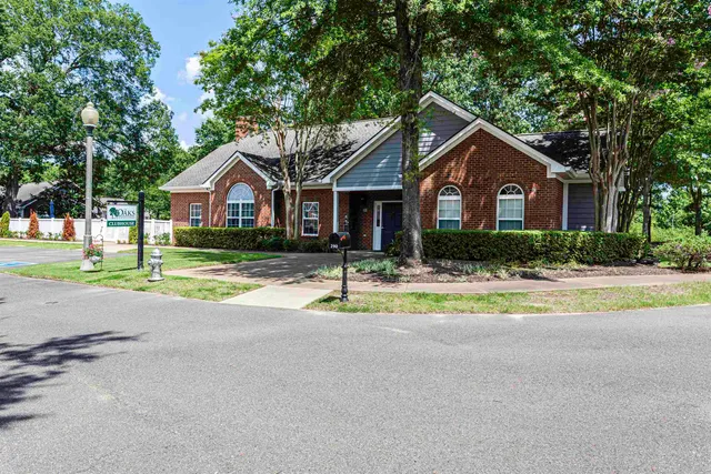 a front view of a house with a yard and trees