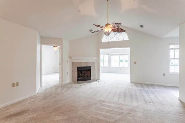 a view of an empty room with a window and fireplace