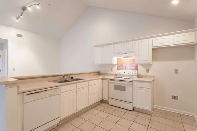 a kitchen with a stove sink and cabinets