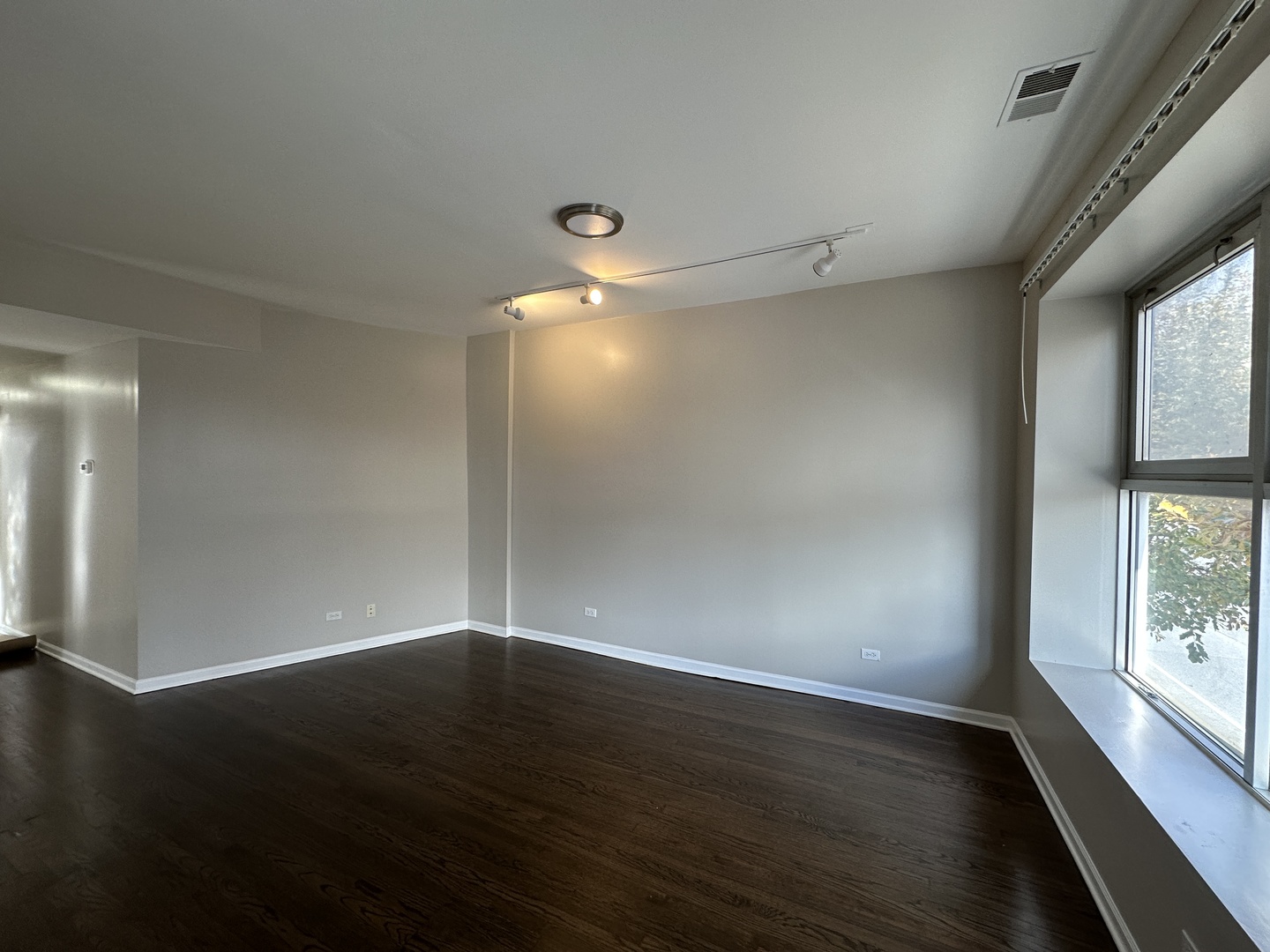 3946 North Cicero Avenue, Unit 1 Chicago, IL 60641 - Photo 2 of 17 an empty room with wooden floor and windows