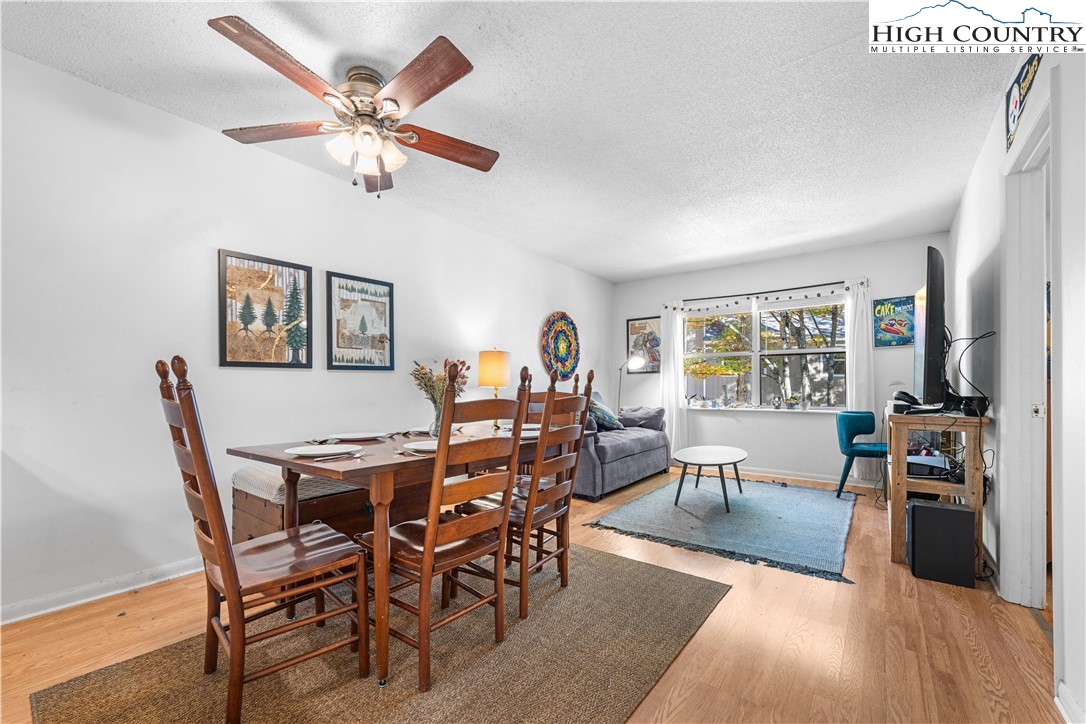 229 East King Street, Unit 17 Boone, NC 28607 - Photo 9 of 22 a view of a dining room with furniture a chandelier and wooden floor