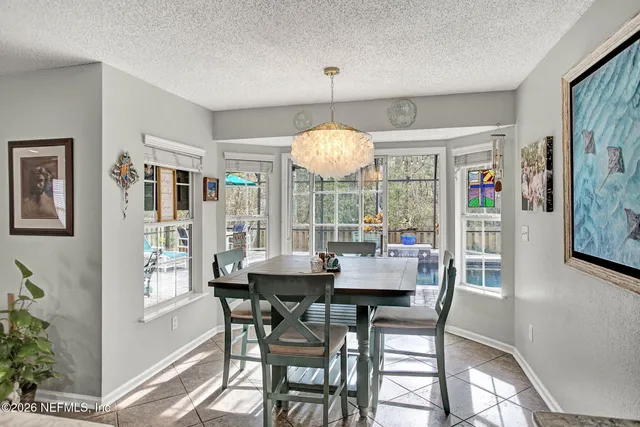 a dining room with wooden floor a chandelier a wooden table and chairs