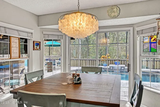 a view of a dining room with furniture and a chandelier