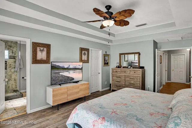 a bedroom with bed and wooden floor