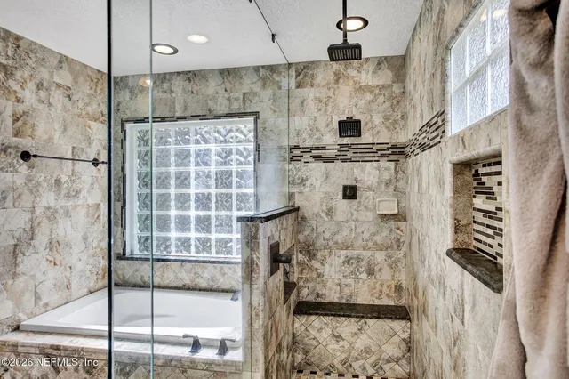 a bathroom with a granite countertop sink a mirror and shower