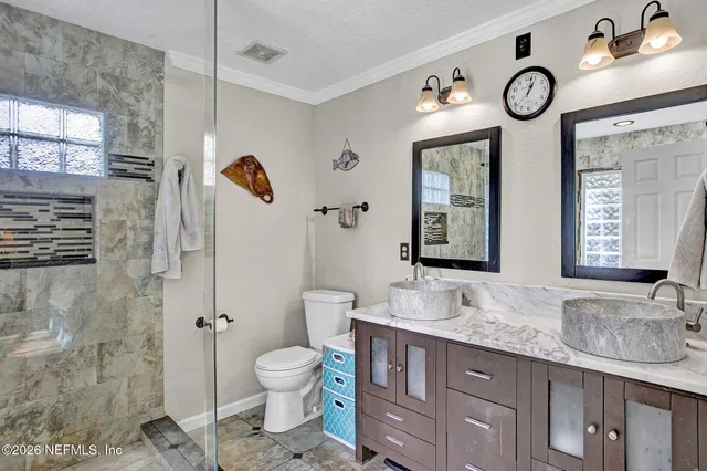 a bathroom with a granite countertop toilet sink and mirror