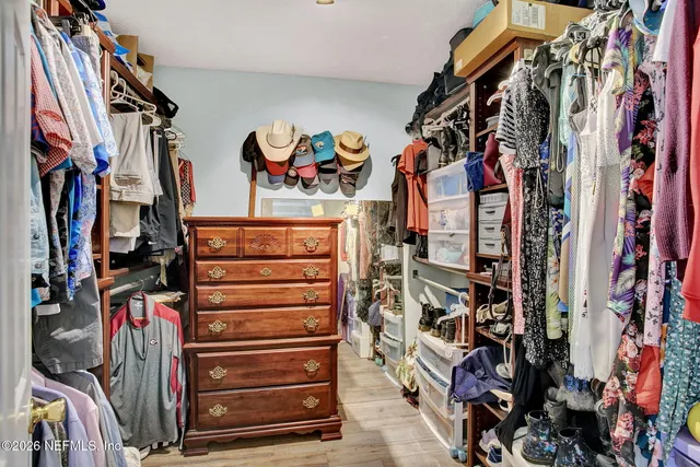 a view of walk in closet with clothes