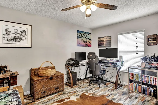 a view of a workspace with furniture and a window