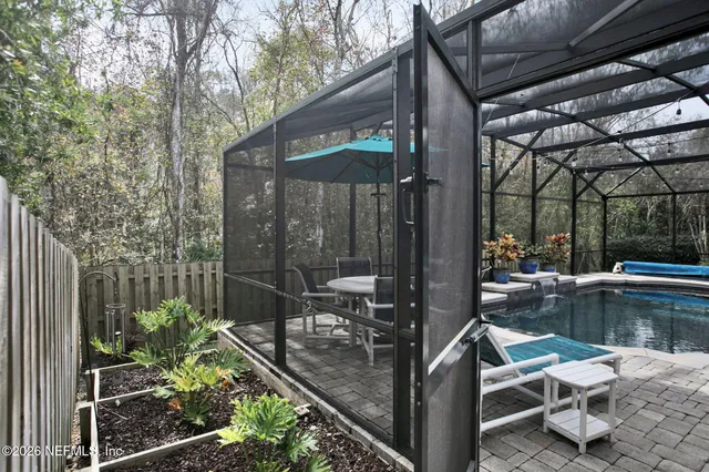 a patio with table and chairs and potted plants