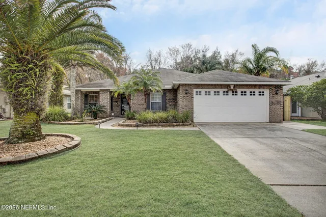 a front view of a house with a garden and plants