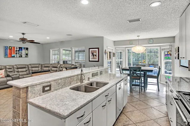 a kitchen with a sink a stove and chairs