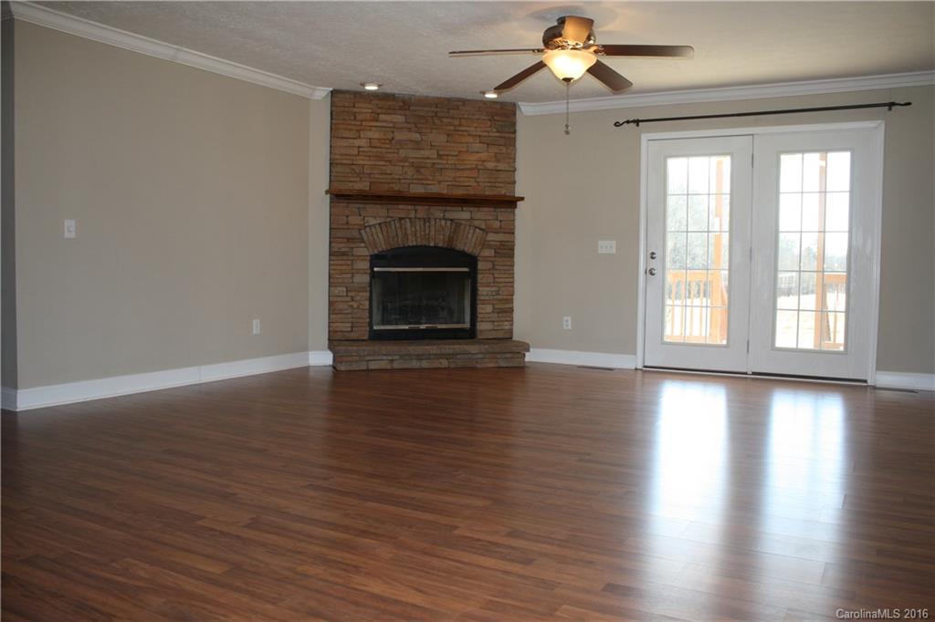 10866 Barberville Road Indian Land, SC 29707 - Photo 6 of 20 a view of an empty room with wooden floor fireplace and a window