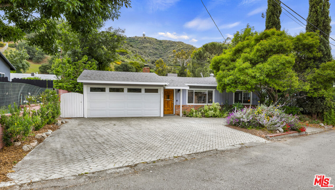 7716 Thousand Oaks Drive Tujunga, CA 91042 - Photo 2 of 34 a front view of a house with a garden and garage