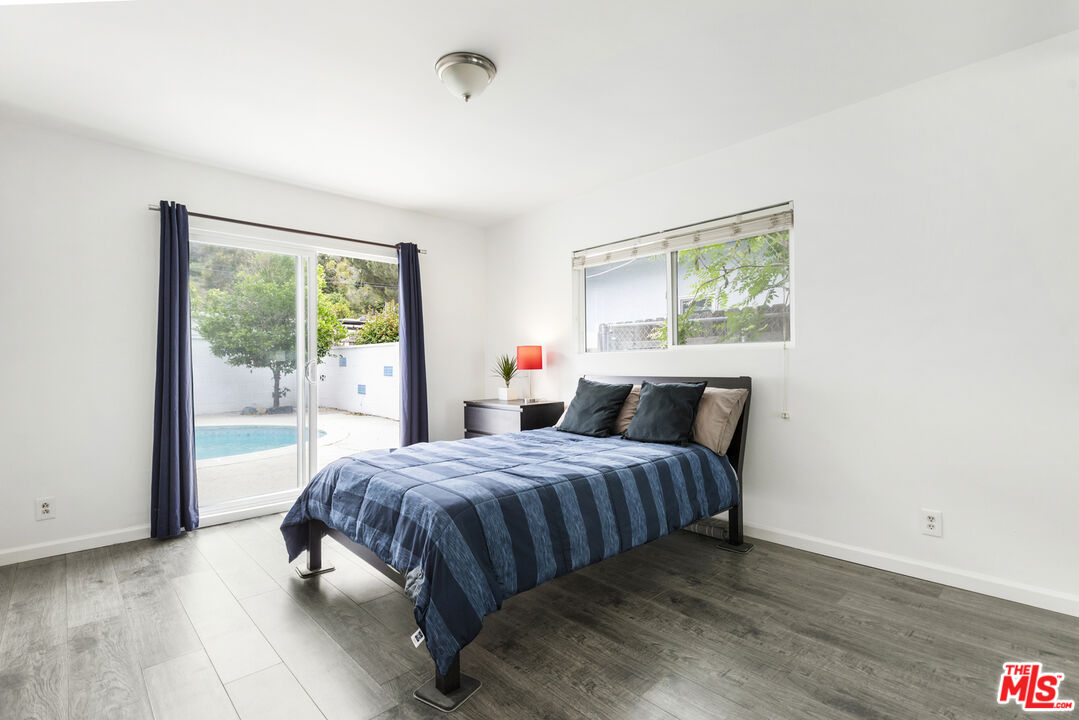 7716 Thousand Oaks Drive Tujunga, CA 91042 - Photo 21 of 34 a bedroom with a bed and wooden floor