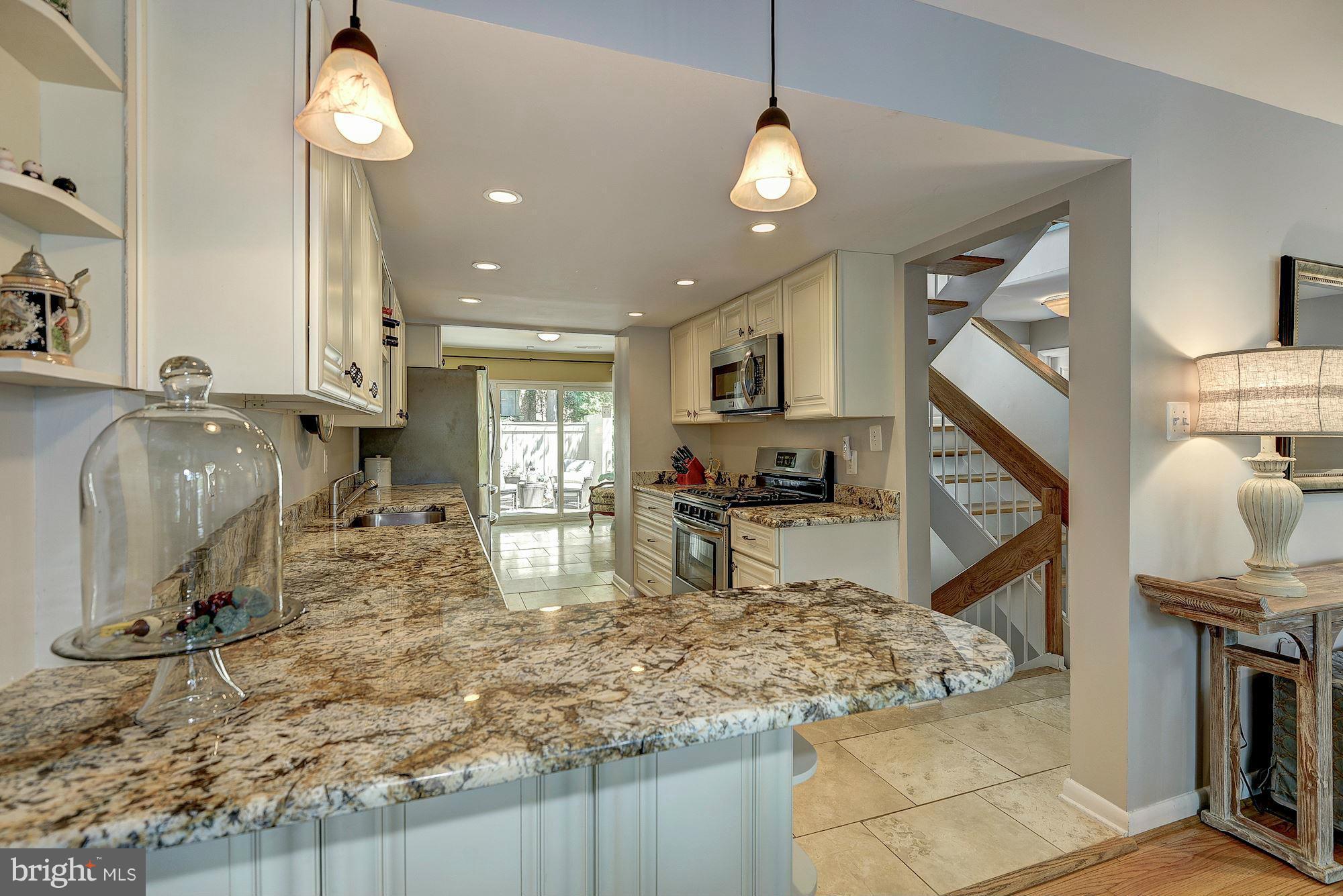 1620 Waters Edge Lane Reston, VA 20190 - Photo 12 of 30 a view of kitchen island with stainless steel appliances granite countertop sink stove top oven and cabinets