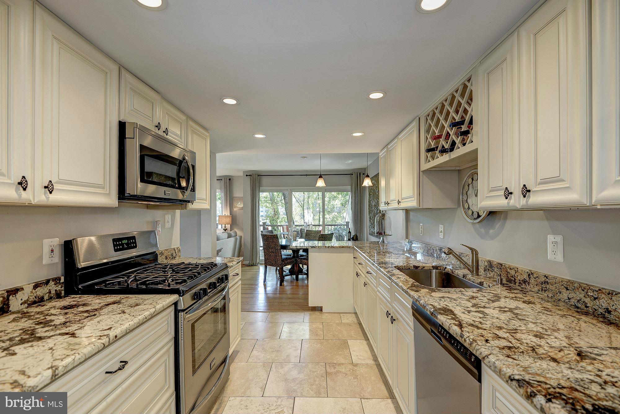 1620 Waters Edge Lane Reston, VA 20190 - Photo 14 of 30 a large kitchen with stainless steel appliances granite countertop a stove a sink dishwasher and a microwave oven with white cabinets