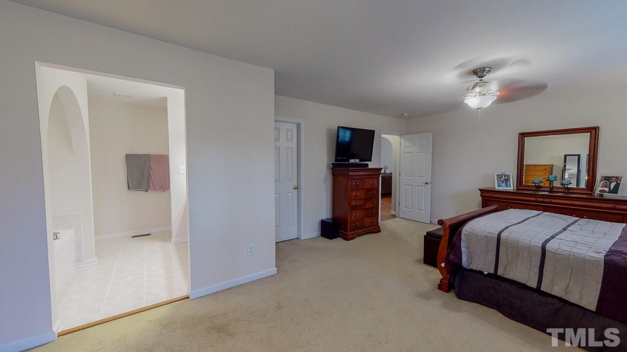 342 Punch Hill Farm Road Rougemont, NC 27572 - Photo 13 of 30 a bedroom with a bed and a flat tv screen on dresser