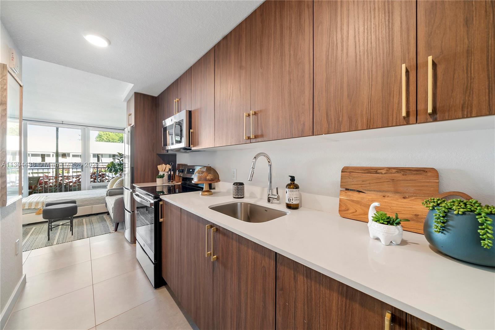 1950 West 49th Street, Unit 213 Hialeah, FL 33012 - Photo 8 of 49 a kitchen with sink a refrigerator and chairs