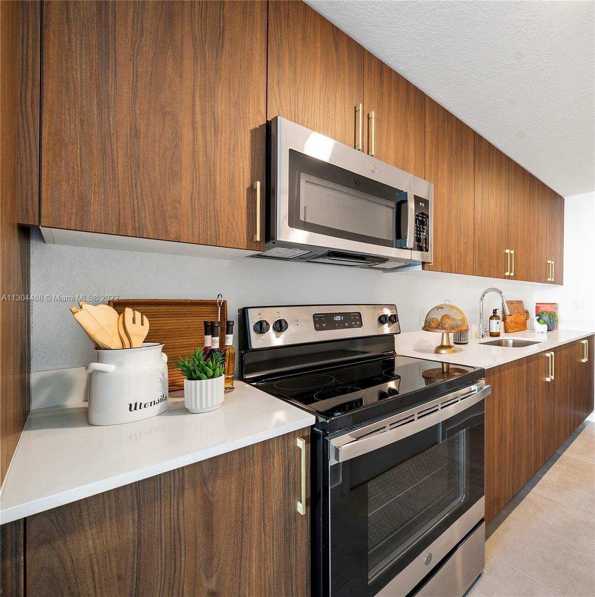 1950 West 49th Street, Unit 213 Hialeah, FL 33012 - Photo 9 of 49 a kitchen with a stove microwave and sink