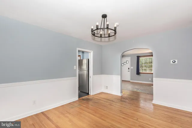 a view of a hallway with wooden floor and chandelier