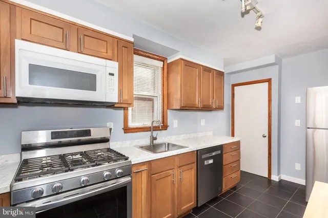 a kitchen with stainless steel appliances granite countertop a stove and a microwave