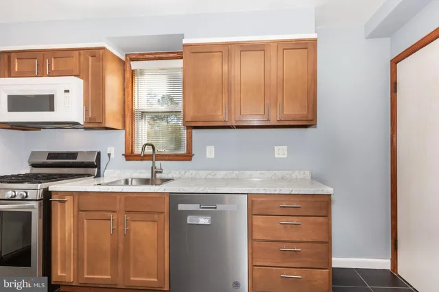 a kitchen with granite countertop cabinets stainless steel appliances and a sink