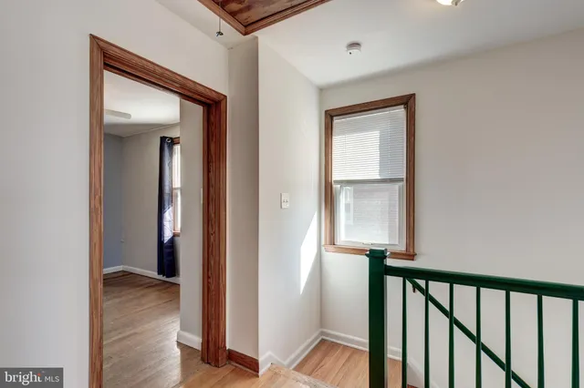 a view of a hallway with wooden floor and entryway