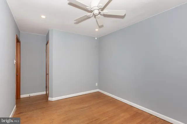 an empty room with a ceiling fan and carpet