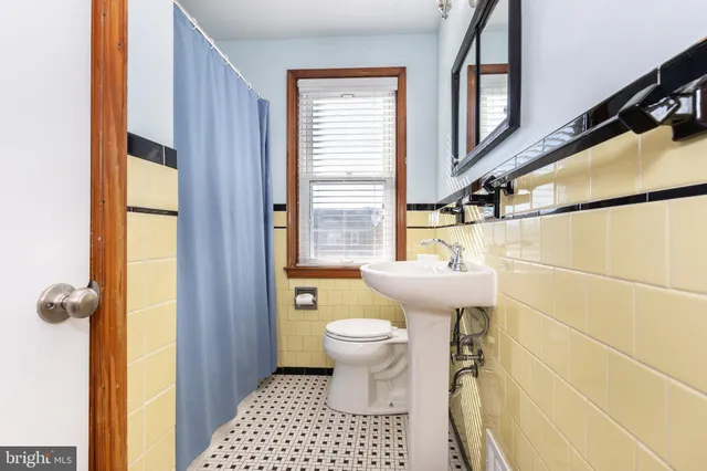 a bathroom with a sink a toilet a window and shower