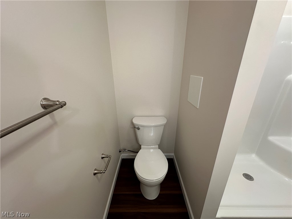 363 Sexton Street Struthers, OH 44471 - Photo 18 of 20 White toilet, dark LTV flooring, and a white shower with integrated seating
