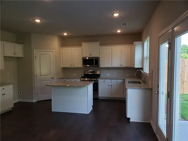 a kitchen with a refrigerator and a stove top oven