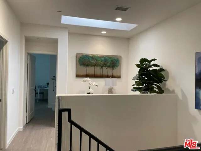 a living room with a flat screen tv furniture and a potted plant