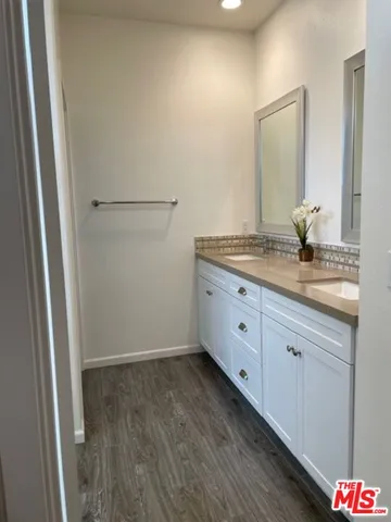 a spacious bathroom with a granite countertop sink and a mirror