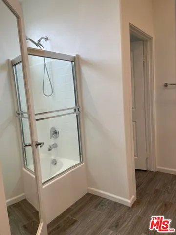 a bathroom with a glass shower door and a mirror