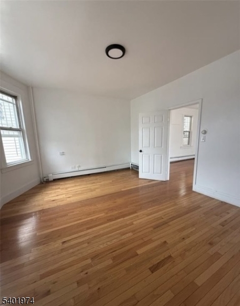 624 Madison Avenue, Unit 2 Elizabeth, NJ 07201 - Photo 3 of 5 an empty room with wooden floor and windows