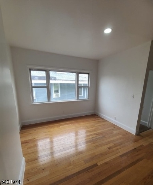 624 Madison Avenue, Unit 2 Elizabeth, NJ 07201 - Photo 4 of 5 a view of an empty room with wooden floor and a window