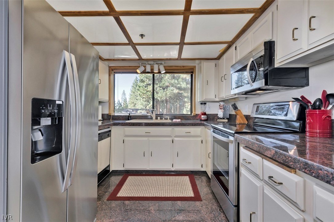 333 Ski Way, Unit 277 Incline Village, NV 89451 - Photo 11 of 33 a kitchen with stainless steel appliances granite countertop a refrigerator a sink dishwasher a stove and white countertops with wooden floor