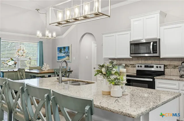 a kitchen with stainless steel appliances granite countertop a refrigerator a stove top oven a sink and dishwasher