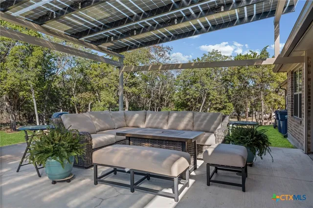 a view of a patio with couches table and chairs with wooden floor and fence
