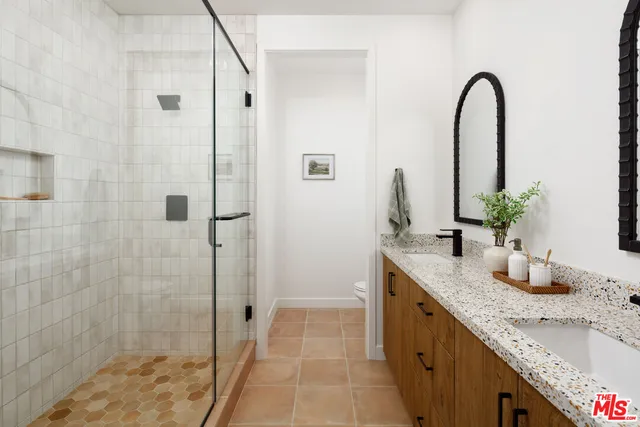 a bathroom with a granite countertop sink a shower and a mirror