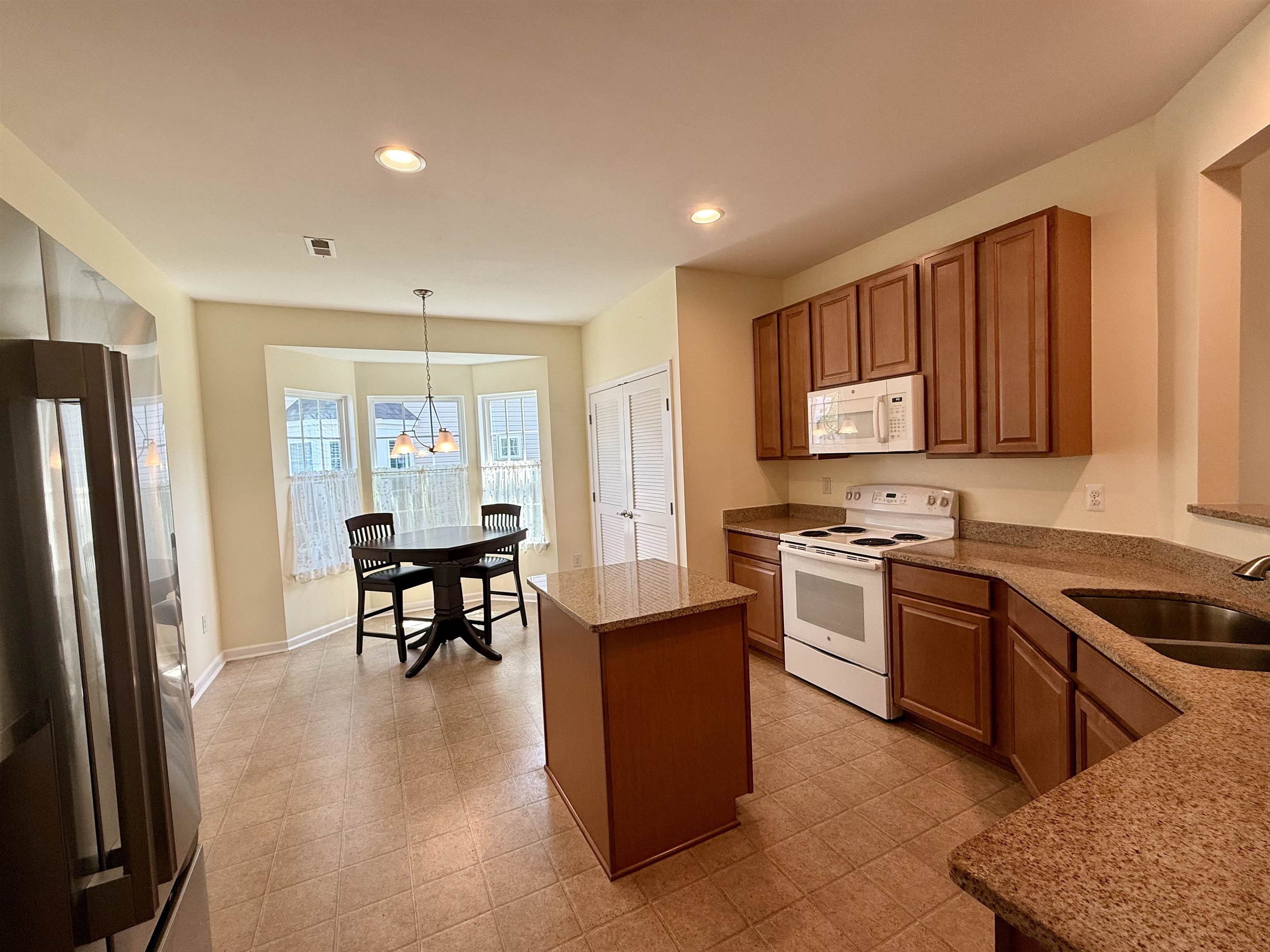 1607 Tidewater Avenue, Unit 1607 Rio Grande, NJ 08242 - Photo 6 of 42 a kitchen with stainless steel appliances granite countertop a stove top oven a sink dishwasher a refrigerator and cabinets with wooden floor