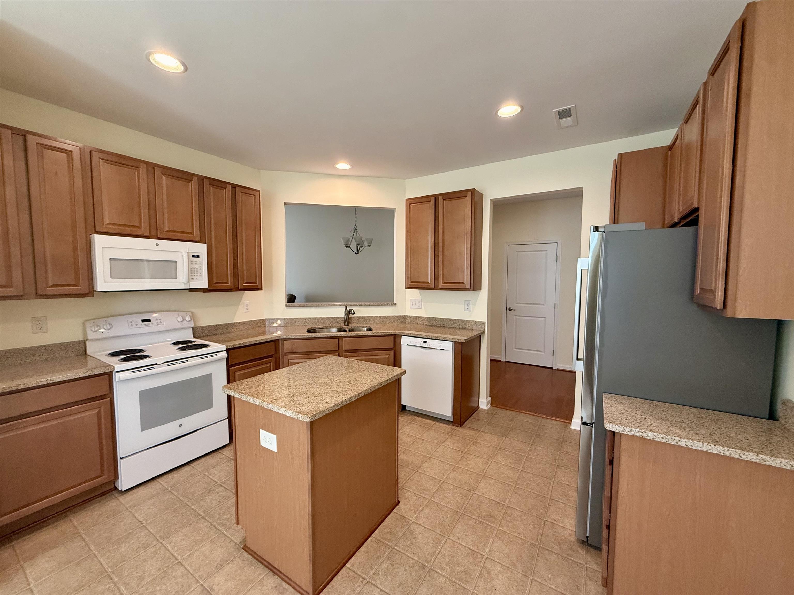 1607 Tidewater Avenue, Unit 1607 Rio Grande, NJ 08242 - Photo 10 of 42 a kitchen with stainless steel appliances granite countertop a stove top oven a sink a refrigerator and white cabinets