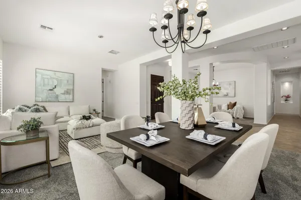 a living room with furniture a chandelier and a dining table