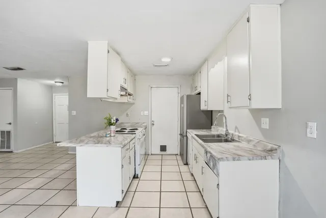a kitchen with sink cabinets and stove top oven