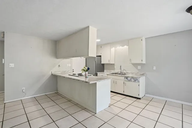 a kitchen with granite countertop a stove a sink and a refrigerator