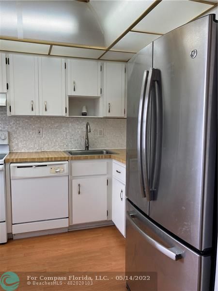 3541 Inverrary Drive, Unit 103 Lauderhill, FL 33319 - Photo 3 of 18 a kitchen with stainless steel appliances granite countertop a refrigerator sink and white cabinets