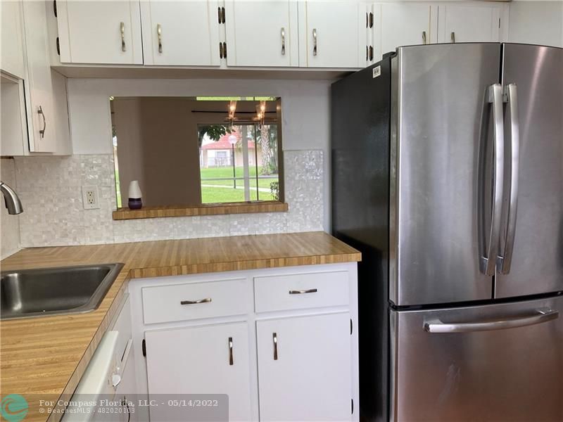 3541 Inverrary Drive, Unit 103 Lauderhill, FL 33319 - Photo 4 of 18 a kitchen with stainless steel appliances granite countertop a refrigerator and a sink